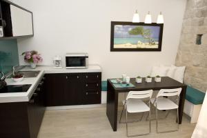 eine Küche mit einem Tisch, Stühlen und einem Waschbecken in der Unterkunft Studio apartment Malo more in Trogir