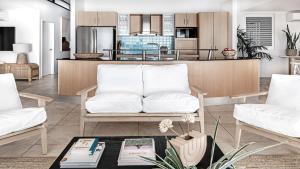 a living room with a white couch and a kitchen at Beachside Lennox 2 in Lennox Head