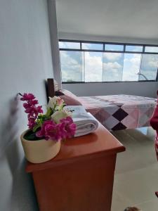 a room with a table with a vase of flowers on it at Picuro Lodging House in Iquitos