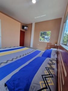 a large room with a large bed with blue sheets at Picuro Lodging House in Iquitos