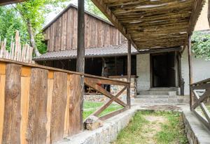 une ancienne grange avec une clôture en bois devant elle dans l'établissement Bukska Sadyba, à Buki