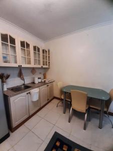 eine kleine Küche mit einem Tisch und einem Waschbecken in der Unterkunft Relaxing / Minimalist homestay - 1 Bed & Bath in Camp John Hay