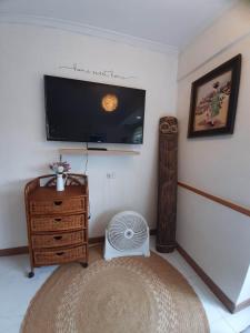 ein Wohnzimmer mit einem Flachbild-TV und einem Ventilator in der Unterkunft Relaxing / Minimalist homestay - 1 Bed & Bath in Camp John Hay