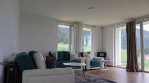 a living room with a couch and chairs and windows at Lotus Villas in Travnik