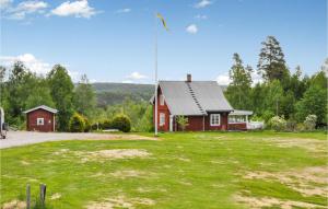 uma casa vermelha com um mastro de bandeira em frente em Stunning Home In Skillingsfors With Kitchen em Gryttved