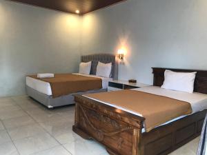 twee bedden in een hotelkamer met twee bedden bij Bello Ethnic Lombok in Tetebatu