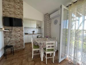 cocina y comedor con mesa y sillas en Apartment Željko - with sea view, en Maslinica