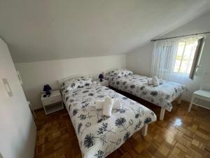 1 dormitorio con 2 camas y ventana en Apartment Željko - with sea view, en Maslinica
