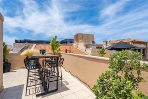 um pátio com uma mesa e cadeiras numa varanda em Monk Rooms em Chania Town