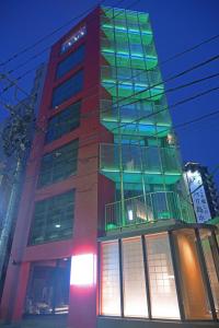 ELE Cabin Shinjuku Kabukicho في طوكيو: مبنى طويل وبه الكثير من النوافذ
