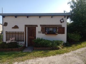 een klein wit huis met een raam en een deur bij La tiote roulotte in Marquigny