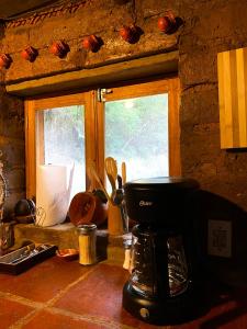 a kitchen counter with a coffee maker and a window at Cabaña en Malinalco Zarla in Malinalco