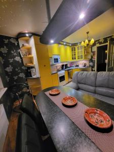 una cocina y una sala de estar con una mesa con platos. en Ranna Sadama Villa, en Pärnu