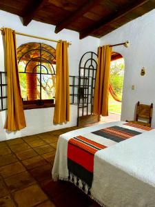 a bedroom with a bed and an arched window at Cabaña en Malinalco Zarla in Malinalco