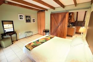 a bedroom with a large white bed and a desk at Emzini Apartments in Midrand