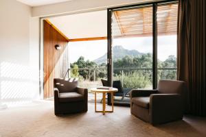 a living room with chairs and a table and a large window at Royal Mail Hotel in Dunkeld