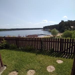 a wooden fence with a view of a lake at Apartament Na Skarpie Czarna Wieś in Rajgród