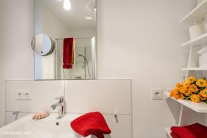 une salle de bain blanche avec un lavabo et un miroir dans l'établissement Heimathafen 3 - M S Atlantis, à Kappeln