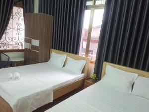 a bedroom with two beds and a window at PHÚC AN HOSTEL in Cat Ba