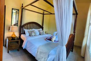 a bedroom with a large bed with a canopy at Giri's Villa Jimbaran in Ungasan