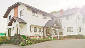 a white house with a black roof at Kusatsuonsen Ventvert in Kusatsu