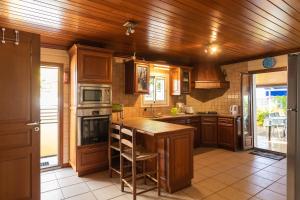 a kitchen with wooden cabinets and a wooden ceiling at la bleue salee in Étang-Salé