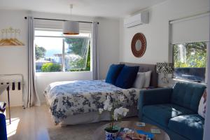 um quarto com uma cama e um sofá azul em Paraparaumu Beachside Studio em Paraparaumu