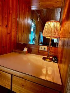 a lamp on a table in a room with wooden walls at Fong Chou Chalet in Sanyi