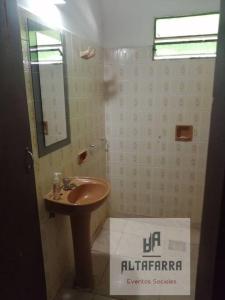 uma casa de banho com um lavatório e um espelho em casa con piscina, alojamiento hasta 12 personas em Assunção