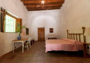 a bedroom with a bed and a table and a window at Hacienda la Luna in Tetecala