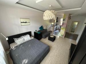 a bedroom with a bed and a living room at Studio apartment in private house in Rīga