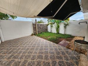 patio z czarnym parasolem i sprzętem do grillowania w obiekcie Hermosa Casa en Jardines Cancún w mieście Cancún