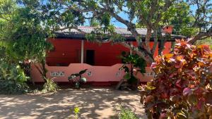 czerwony dom z drzewem przed nim w obiekcie Coconut Leaf Shadow Guest w mieście Nilaveli