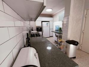 a kitchen with a counter and a white refrigerator at אחוזת דולב Dolev estate הווילה in Zanoaẖ