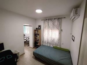 ein Schlafzimmer mit einem grünen Bett und einem Fenster in der Unterkunft אחוזת דולב Dolev estate הווילה in Zanoaẖ