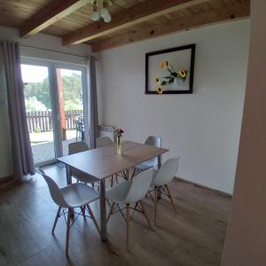 a dining room with a wooden table and chairs at Apartament Na Skarpie Czarna Wieś in Rajgród