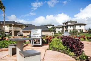 una parrilla en un patio frente a algunas casas en Pili Mai 12I, en Koloa