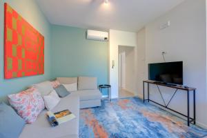 ein Wohnzimmer mit einem Sofa und einem TV in der Unterkunft Casa Lia - Happy Rentals in Desenzano del Garda