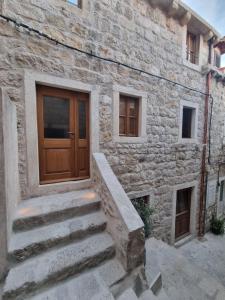 um edifício de pedra com uma porta de madeira e escadas em Old Town Olive Studio Apartment em Dubrovnik