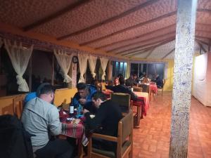 a group of people sitting at tables in a restaurant at Refugio Ecologico Kalluchi in Comunidad Yumani