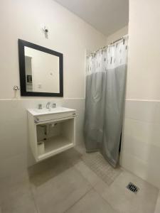 Fama Suite YB في La Rinconada: حمام أبيض مع حوض ومرآة