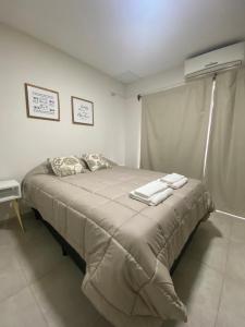 Fama Suite YB في La Rinconada: غرفة نوم عليها سرير وفوط