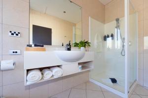 a bathroom with a sink and a shower at Harvest Lodge Motel in Havelock North