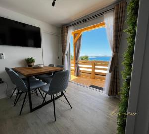 a dining room with a table and chairs and a balcony at Mobile home d-view in Drage
