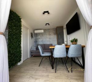 sala de estar con mesa, sillas y sofá en d-view Premium Mobile Home - panoramic seaview - 150 m from beach, free parking en Drage