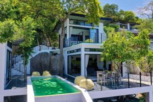 an exterior view of a house with a swimming pool at Pahili Pool Villas - SHA Plus in Ko Tao
