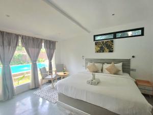 um quarto com uma cama e uma grande janela em Tisha Langkawi Wellness Resort em Pantai Cenang