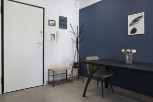 ein Esszimmer mit einem Tisch und einer blauen Wand in der Unterkunft Comfort & Relax apartment in Athens Riviera in Athen