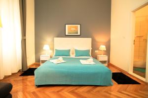 a bedroom with a large bed with two towels on it at Contarini Luxury Rooms in Split