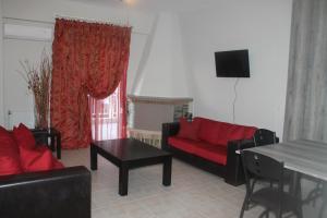 a living room with a red couch and a table at Paralia Apartments in Paralia Katerinis